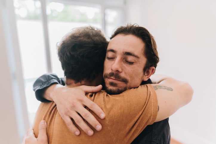 Father and son embracing at home